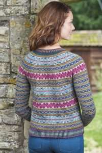 Blacker Yarns The Knitter Features Jura Cardigan in Tamar Lustre Yarn Woman standing with back to camera wearing fair isle cardigan knitted in Blacker Yarns wool